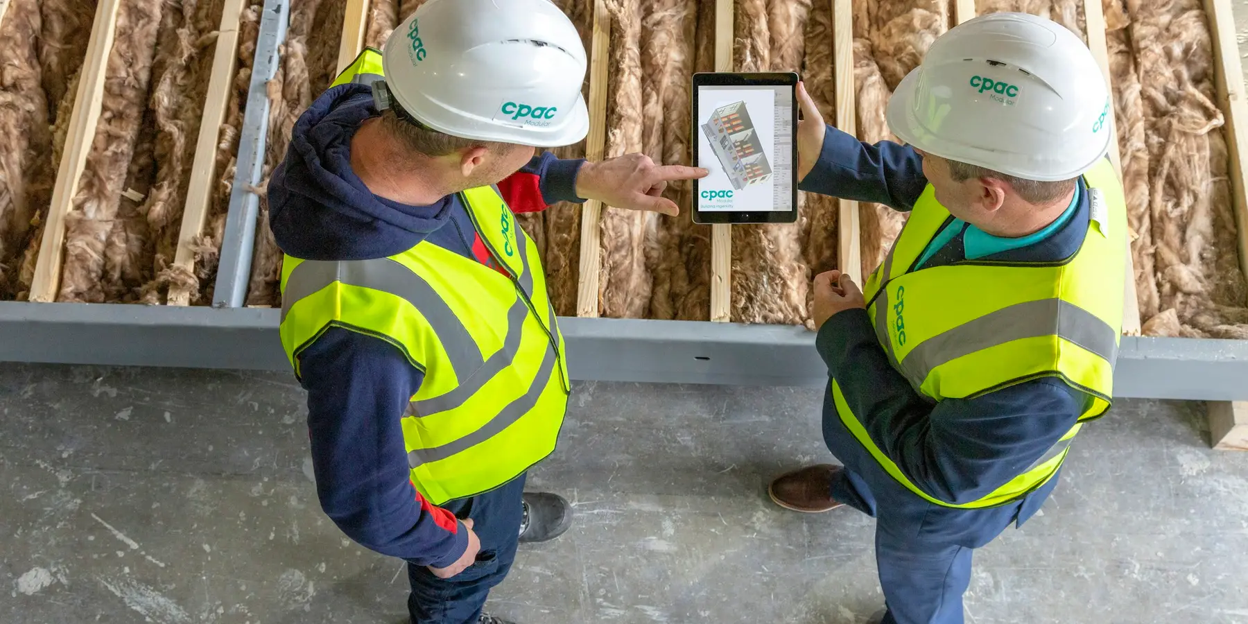 Two crew members working off a tablet on site