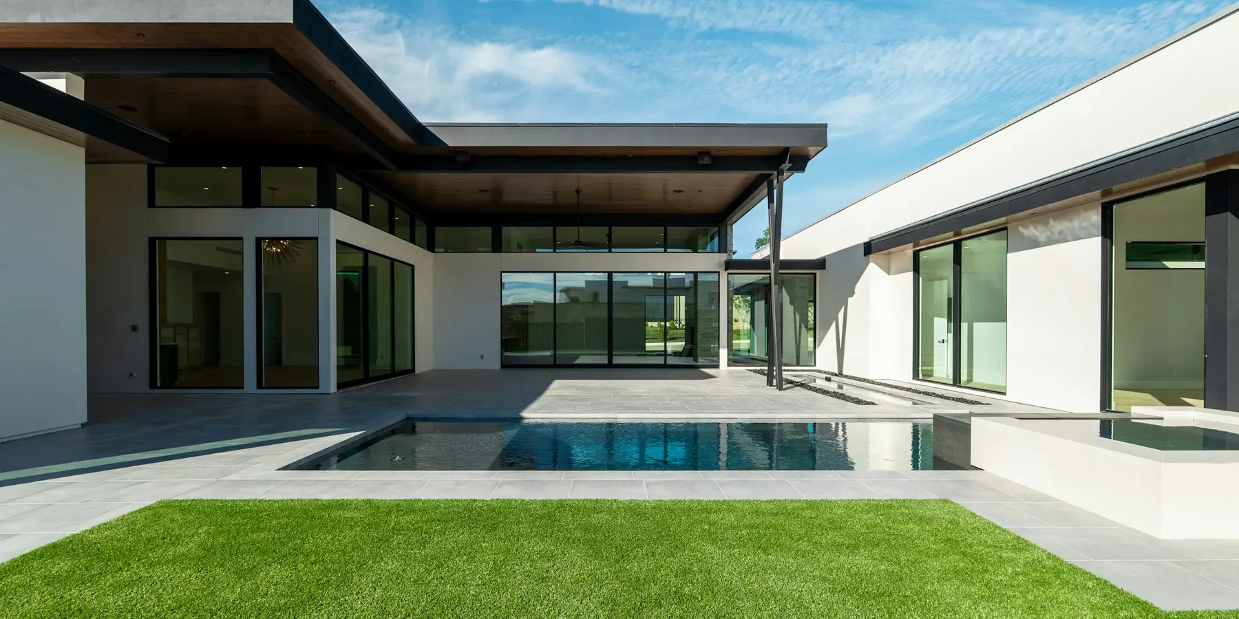 A property with a lawn and a pool, from the front